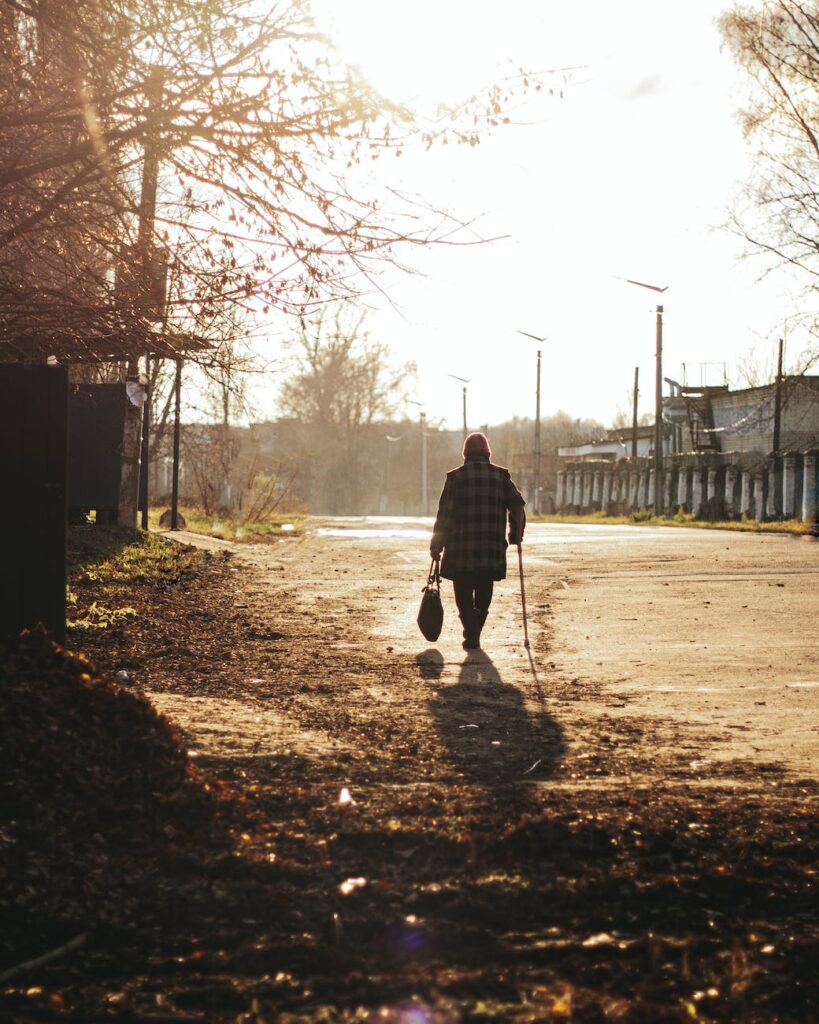 woman using walking cane walking through street